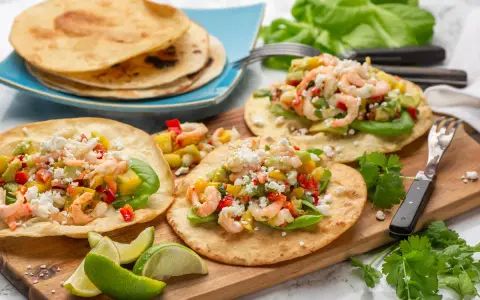 Tre läckra tostadas de camarón med räkor, avokado och mango. Serveras med limeklyftor och färsk koriander.
