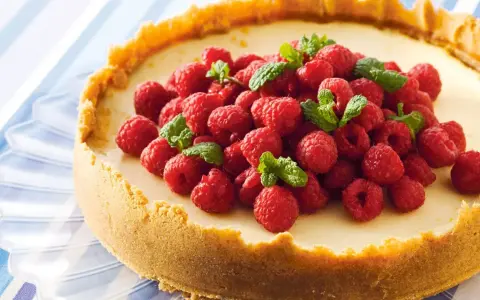 Klassisk ugnsbakad cheesecake med hallon och mynta. En perfekt receta de cheesecake tradicional al horno för alla tillfällen.