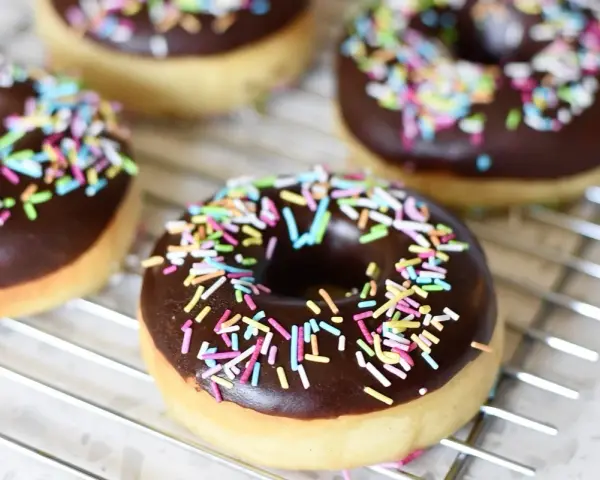 Färska munkar med chokladglasyr och färgglatt strössel. Perfekt för att inspireras av nya recetas de donas.
