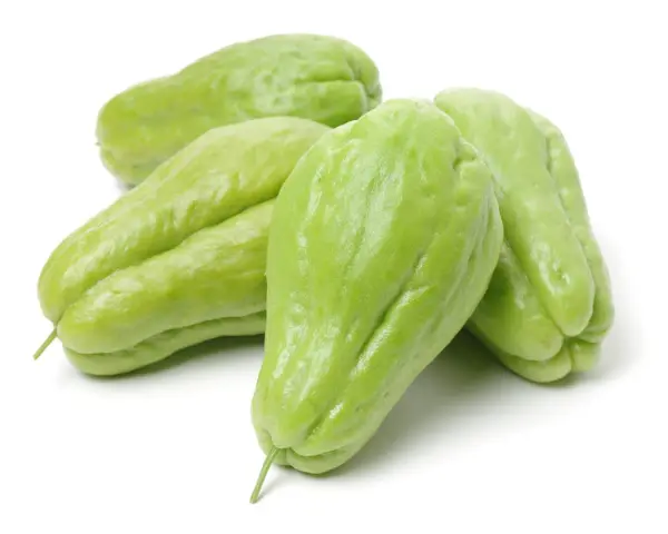 En grupp ljusgröna chayote-frukter, även kända som "que es chayote", ligger på en vit bakgrund.