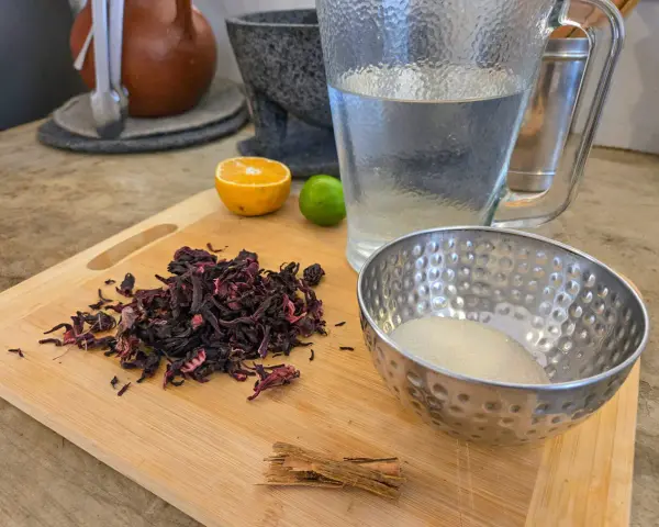 Torkade hibiskusblommor, socker, kanel, lime och apelsin för att göra agua de jamaica, känd för sina hälsofördelar.