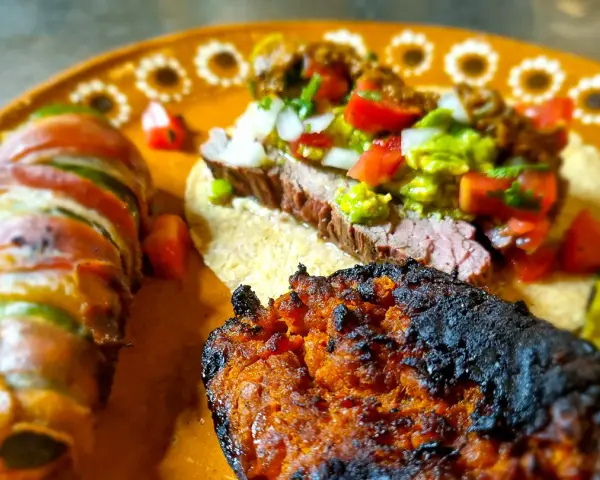 En läcker tallrik med mexikansk mat: en taco med saftig entraña de res, jalapeños inslagna i bacon och en kryddig chorizo.