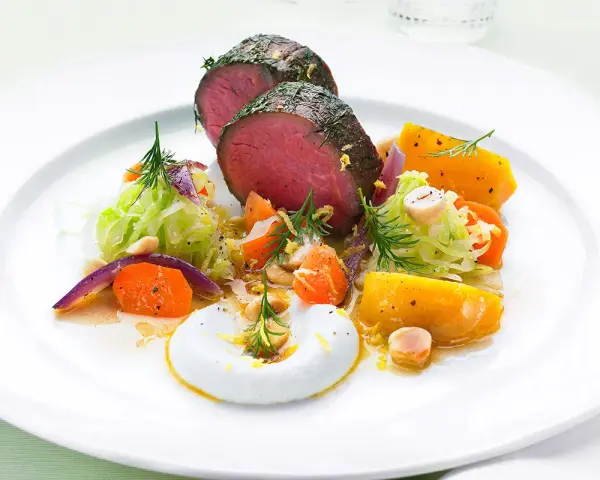 Saftigt lomito con vegetales, med rostade rotfrukter, krispig kål och en krämig sås.