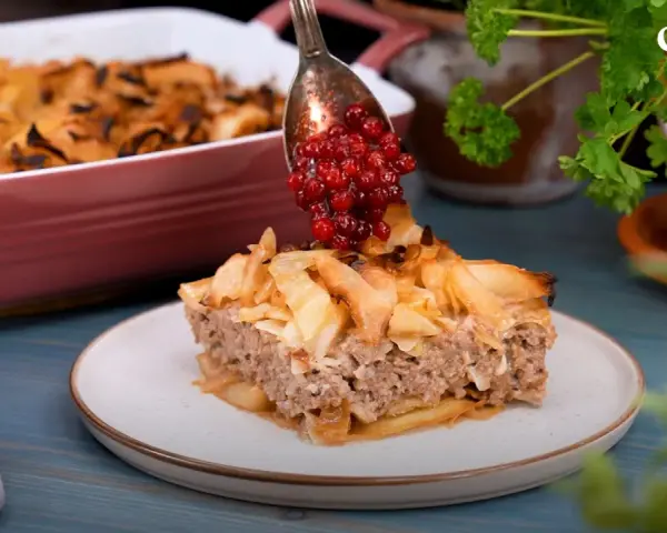 En bit av en saftig köttfärspaj, "tortas de carne", toppas med lingon. Enkel och god vardagsmat.