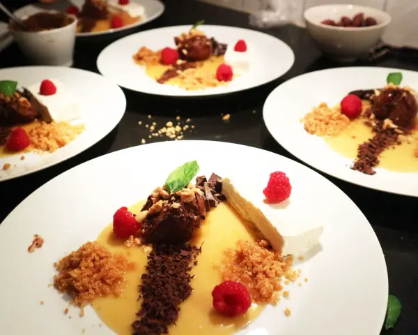 Eleganta desserter med choklad, hallon och en gyllene sås som påminner om dulce de tamarindo.