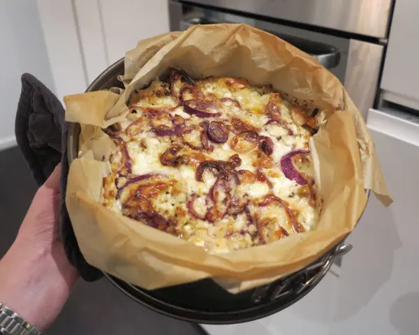 En nybakad paj med lök och ost, ett av hemligheterna i köket.