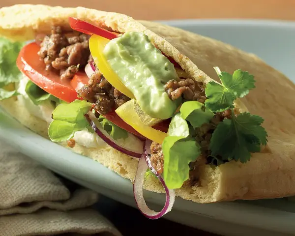 En smakrik pitabrödssmörgås fylld med köttfärs, grönsaker och en krämig sås. Perfekt för snabba och goda **recetas con pan arabe**.