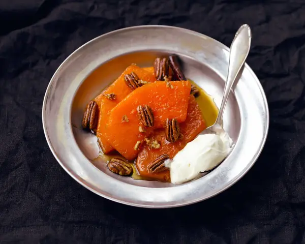 Söta, honungsglaserade pumpaskivor med pekannötter och en klick grädde. En härlig ayote en miel-dessert.