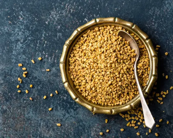 En skål med fenugreekfrön, som är en krydda som används i matlagning.