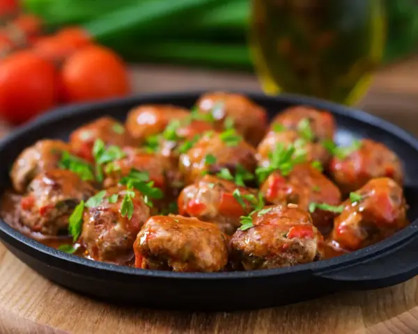 Läckra köttbullar i tomatsås, perfekt för "como hacer albondigas". Garnerade med färsk persilja.