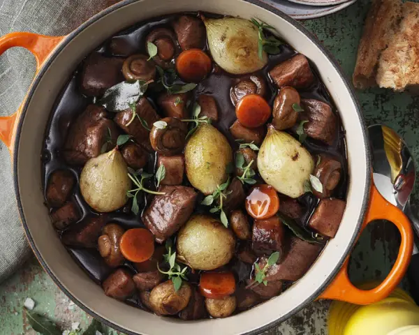 En gryta med mustig köttgryta, svamp, morötter och hela små lökar. Perfekt för att laga en smakrik "posta de yugo para que sirve" – en rätt som värmer själen.