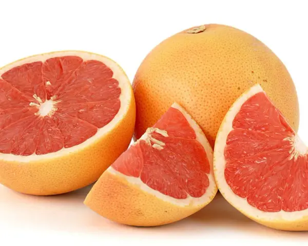 En hel och skivad rosa grapefrukt. Denna saftiga pomelo que es är en uppfriskande citrusfrukt.