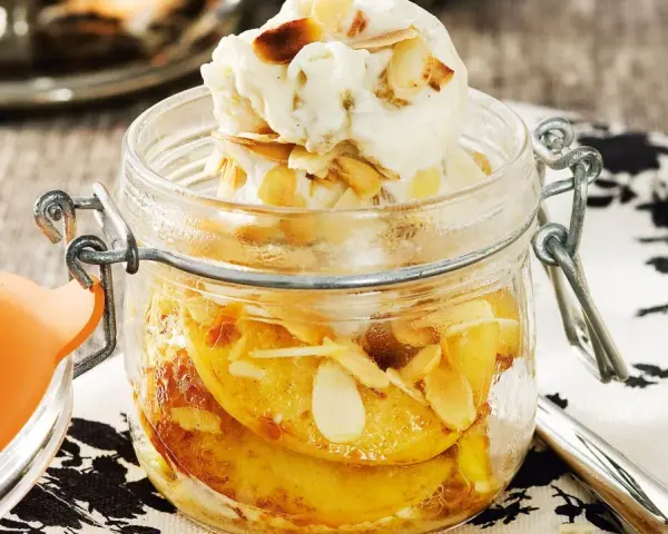 En härlig dessert i glasburk med äppelbitar, mandelflagor och en kula vaniljglass. En perfekt avslutning på måltiden, som en söt ron con pasas.