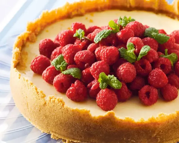 Klassisk ugnsbakad cheesecake med hallon och mynta. En perfekt receta de cheesecake tradicional al horno för alla tillfällen.