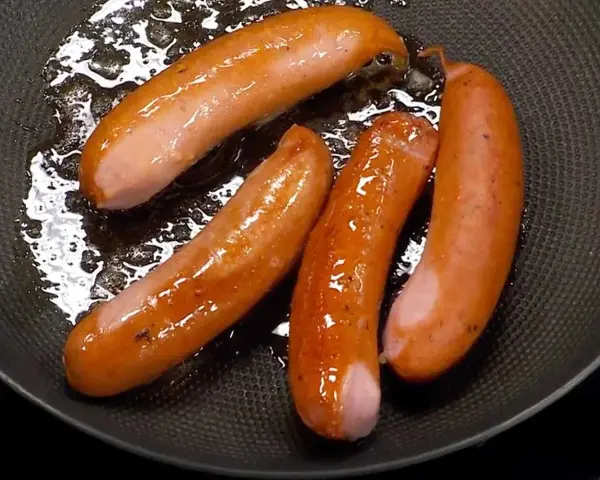 Stekta korvar i panna, en perfekt start för como hacer hot dog.