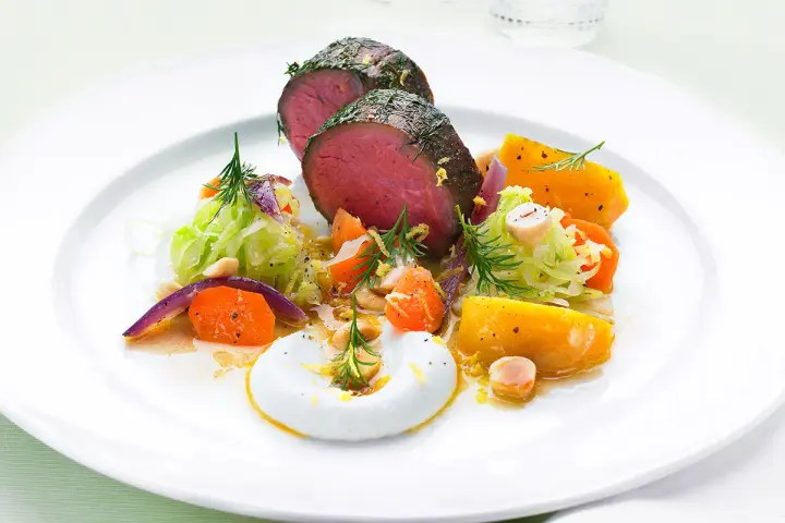 Saftigt lomito con vegetales, med rostade rotfrukter, krispig kål och en krämig sås.
