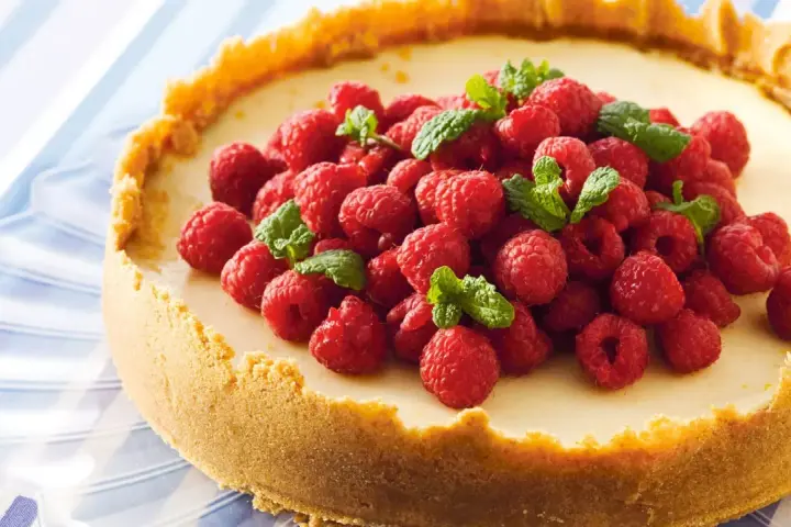 Klassisk ugnsbakad cheesecake med hallon och mynta. En perfekt receta de cheesecake tradicional al horno för alla tillfällen.
