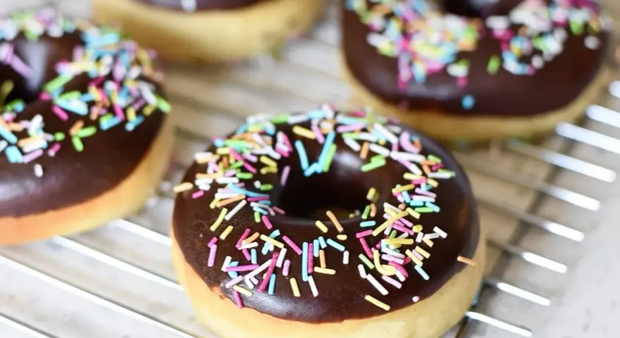 Färska munkar med chokladglasyr och färgglatt strössel. Perfekt för att inspireras av nya recetas de donas.