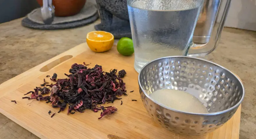 Torkade hibiskusblommor, socker, kanel, lime och apelsin för att göra agua de jamaica, känd för sina hälsofördelar.