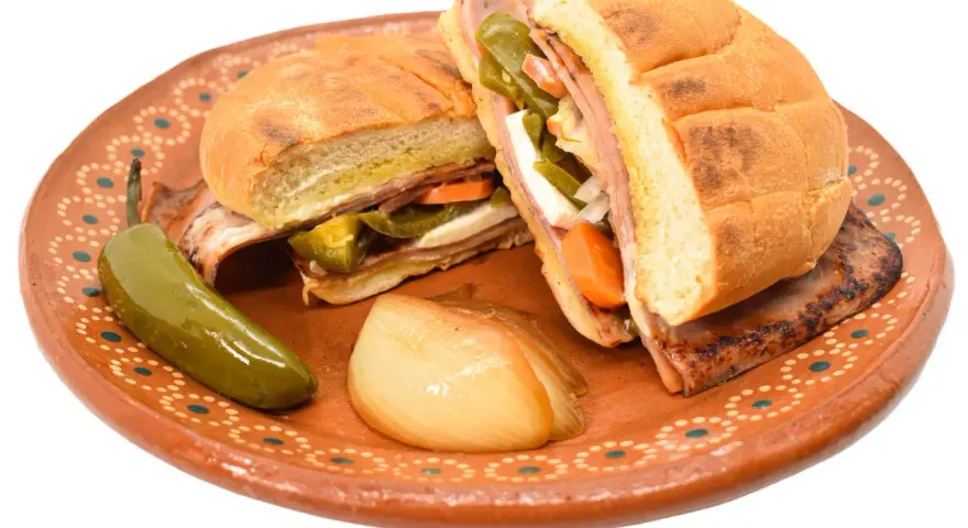 En saftig torta de jamón med jalapeños, morötter och ost på en vacker lertallrik.