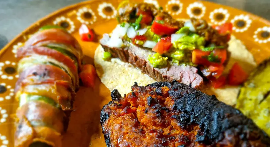 En läcker tallrik med mexikansk mat: en taco med saftig entraña de res, jalapeños inslagna i bacon och en kryddig chorizo.