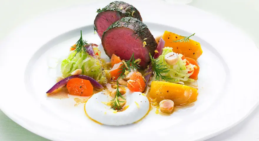 Saftigt lomito con vegetales, med rostade rotfrukter, krispig kål och en krämig sås.