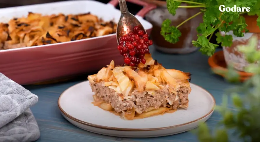 En bit av en saftig köttfärspaj, "tortas de carne", toppas med lingon. Enkel och god vardagsmat.