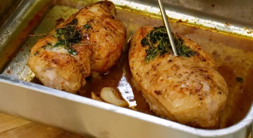 Två saftiga kycklingbröst i en ugnsform, redo att serveras. Perfekt för dina **recetas de pollo**!