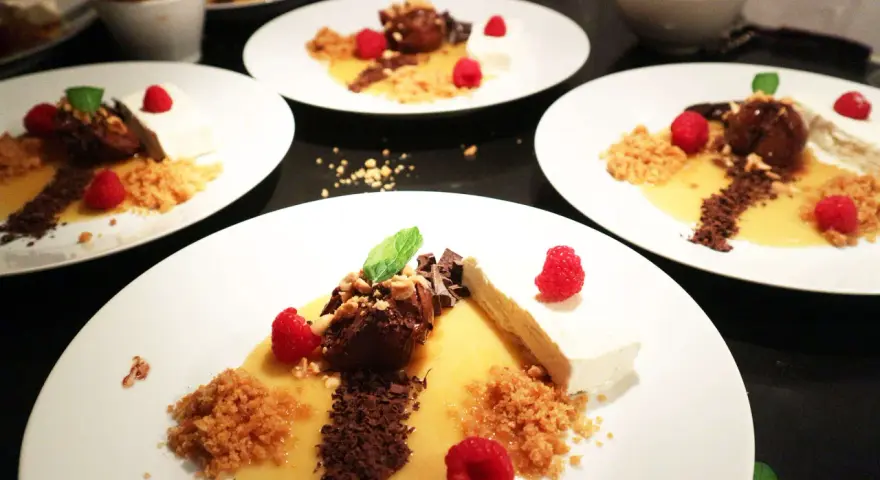 Eleganta desserter med choklad, hallon och en gyllene sås som påminner om dulce de tamarindo.