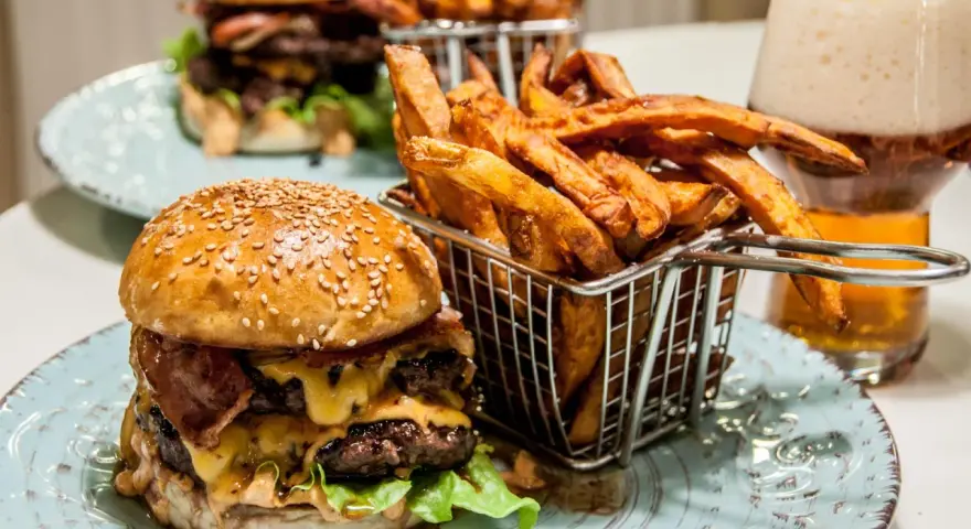 En saftig hamburguesa con papas frites i en korg, redo att avnjutas. En perfekt måltid för en hungrig själ.