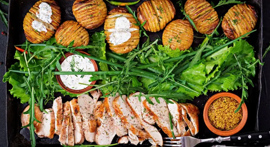 En härlig bricka med saftig kyckling, krispiga Hasselbackspotatisar och fräsch sallad. Perfekt för **cenas saludables y ligeras** – hälsosamma och lätta middagar.