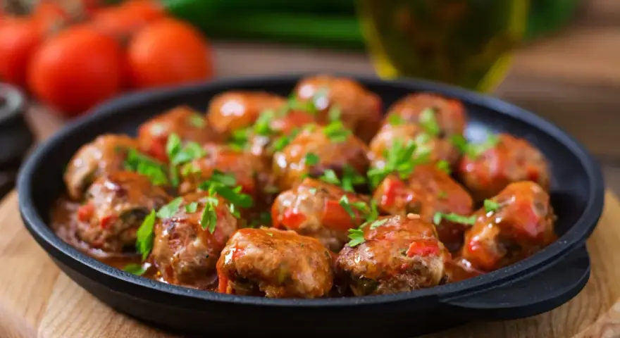 Läckra köttbullar i tomatsås, perfekt för "como hacer albondigas". Garnerade med färsk persilja.