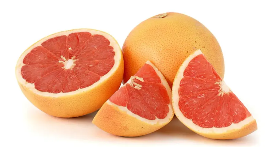 En hel och skivad rosa grapefrukt. Denna saftiga pomelo que es är en uppfriskande citrusfrukt.