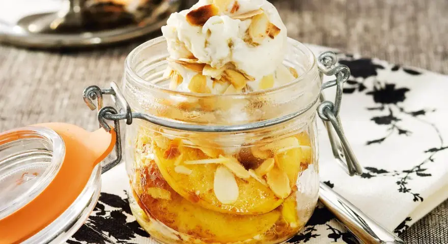 En härlig dessert i glasburk med äppelbitar, mandelflagor och en kula vaniljglass. En perfekt avslutning på måltiden, som en söt ron con pasas.