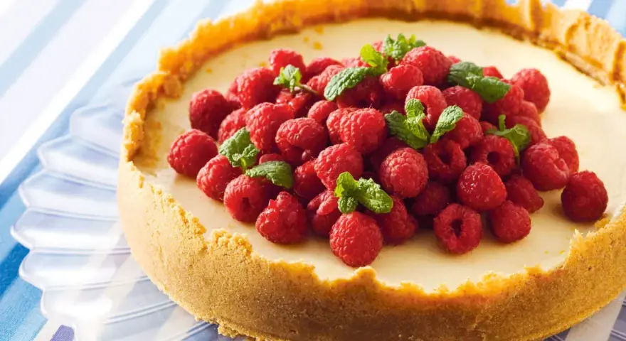 Klassisk ugnsbakad cheesecake med hallon och mynta. En perfekt receta de cheesecake tradicional al horno för alla tillfällen.