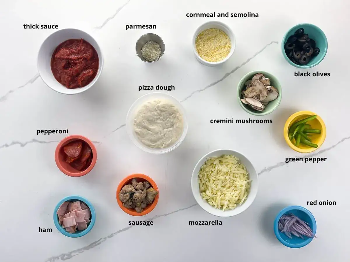 Alla ingredienser f&ouml;r pizza: tomats&aring;s, ost, pepperoni, skinka, korv, svamp, oliver, paprika, l&ouml;k, majsmj&ouml;l och deg.