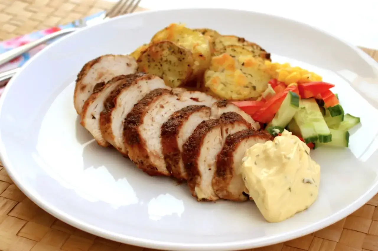 Skivad, kryddad carne de pollo med potatis, majs, paprika och gurka. En klick majonnäs fulländar rätten.
