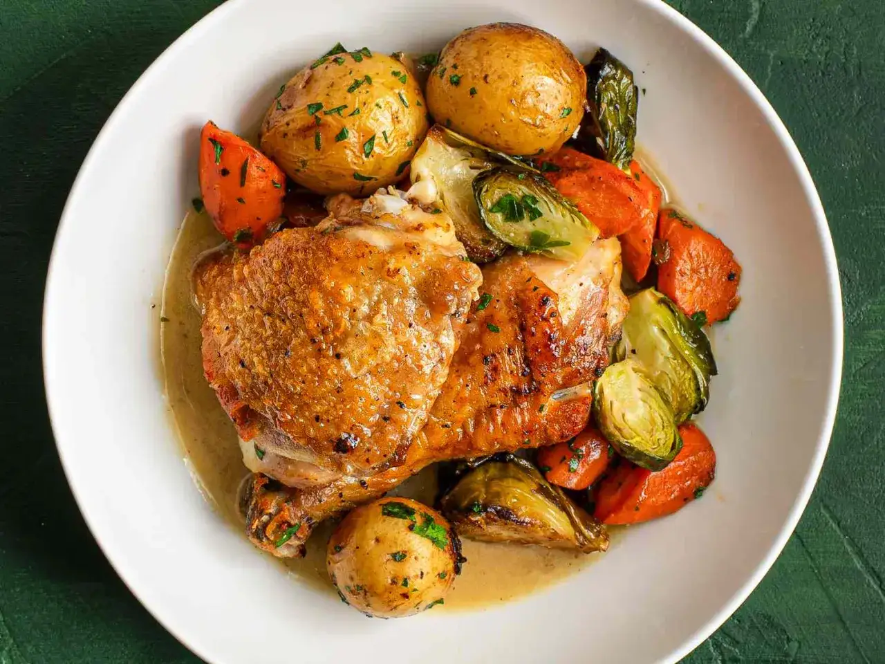 En tallrik med saftig kyckling, rostade rotfrukter och brysselkål. Perfekt för inspiration till dina egna recetas de pollo.