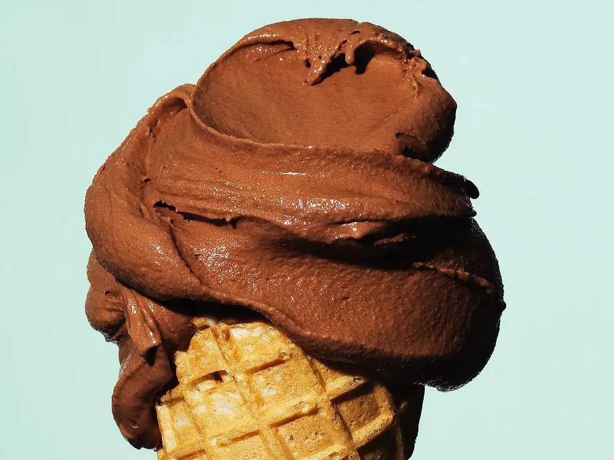 En krämig helado de chocolate som smälter över en krispig våffla.