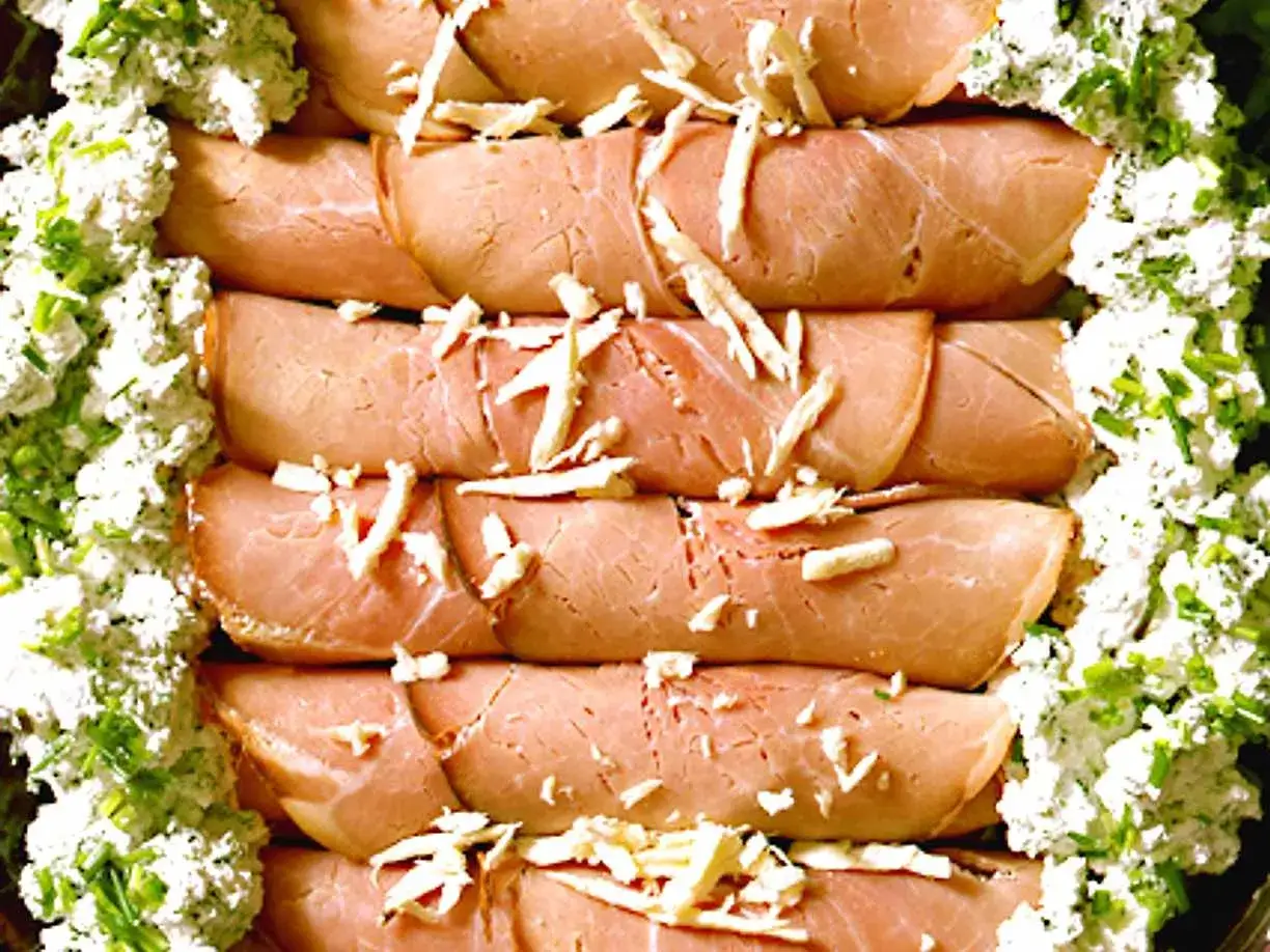 Rullade skinkskivor, enrollados de jamon, toppade med ost och serverade med en krämig ost- och gräslöksröra.