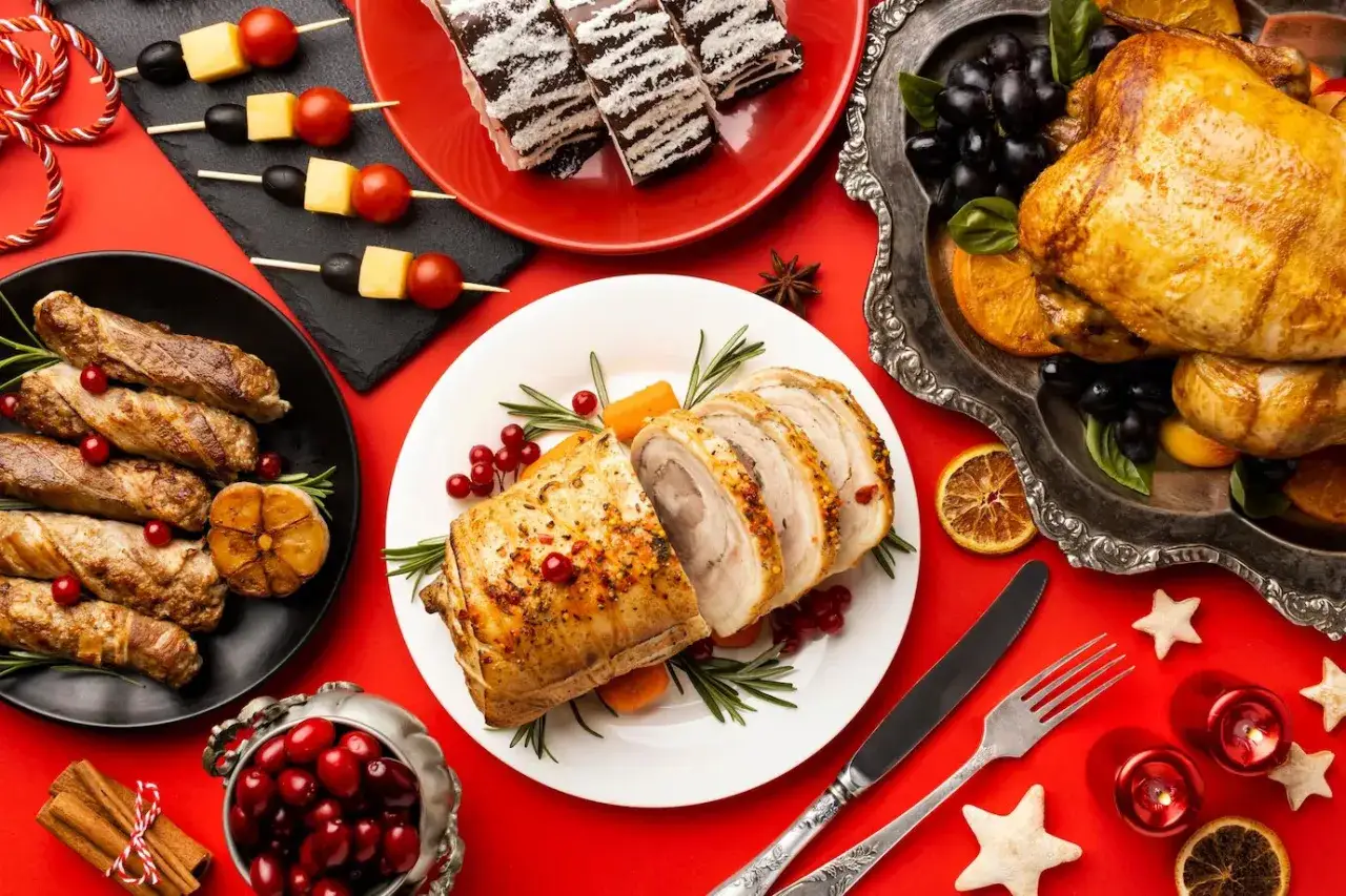 En festlig dukning med en saftig pernil de cerdo, helstekt kyckling, korvar, bär och juldekorationer.