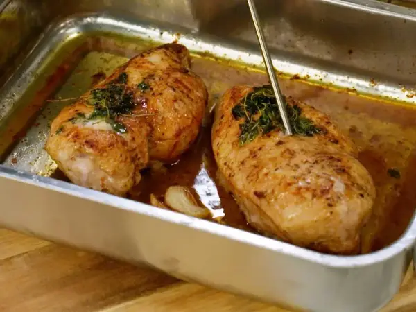 Två saftiga kycklingbröst i en ugnsform, redo att serveras. Perfekt för dina **recetas de pollo**!