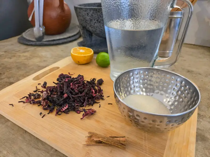 Torkade hibiskusblommor, socker, kanel, lime och apelsin för att göra agua de jamaica, känd för sina hälsofördelar.