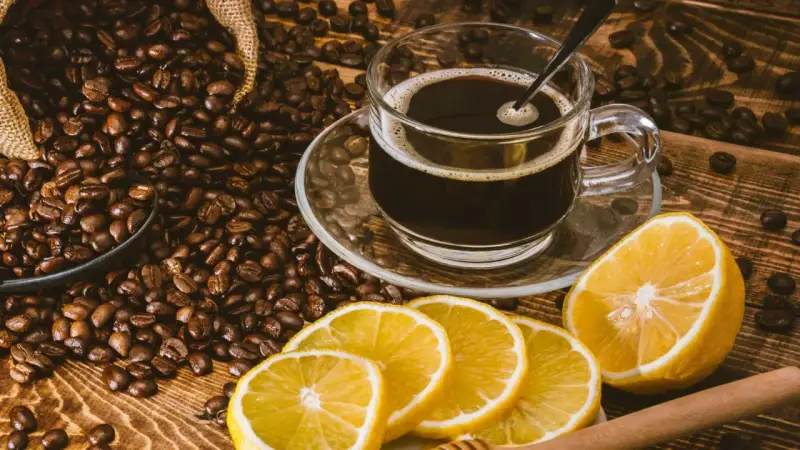 En kopp kaffe med citron, omgiven av rostade kaffebönor. En unik kombination för en café con limón-upplevelse.
