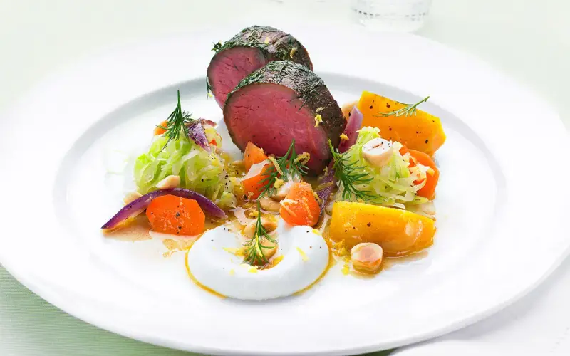 Saftigt lomito con vegetales, med rostade rotfrukter, krispig kål och en krämig sås.