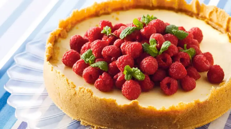 Klassisk ugnsbakad cheesecake med hallon och mynta. En perfekt receta de cheesecake tradicional al horno för alla tillfällen.